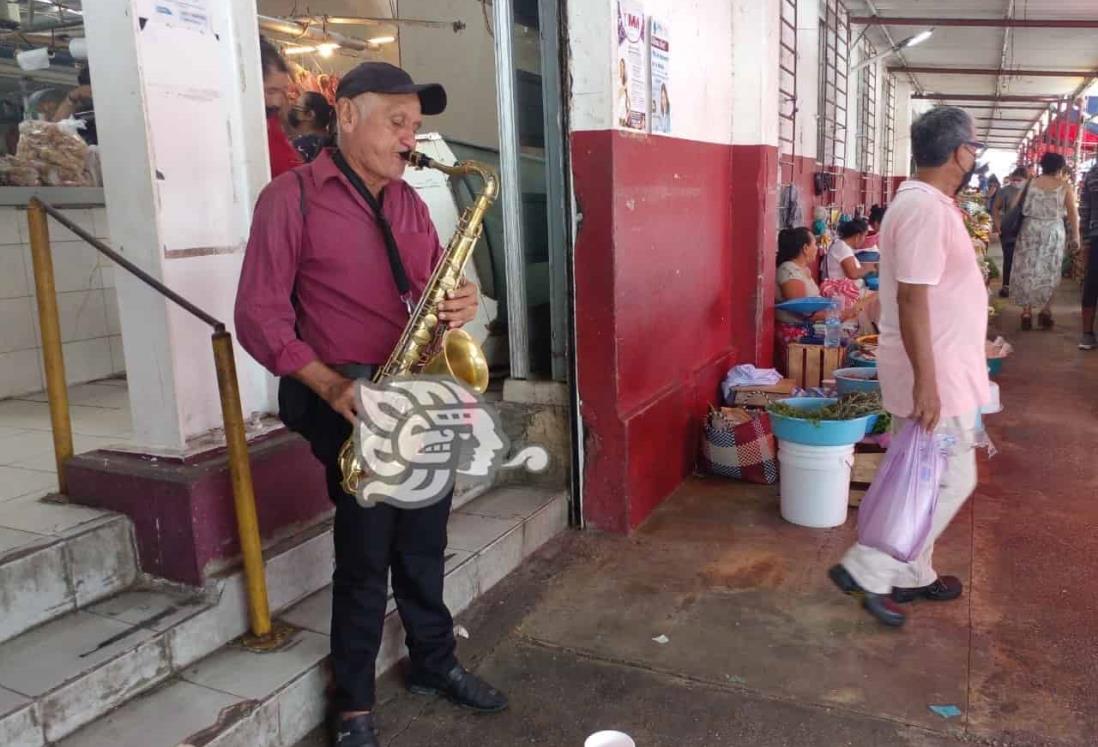 (+ Video) Saxofonista a falta de tocadas, pesetea en los mercados